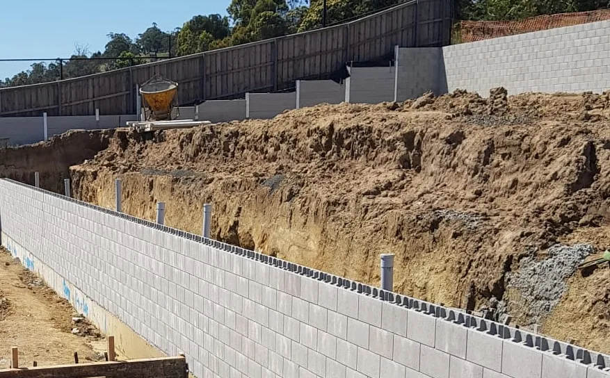 Blockwork retaining wall with steel starter bars running the length of a sloping site