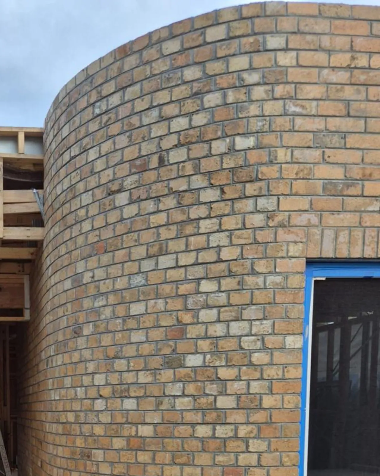 Curved recycled brick feature wall under construction